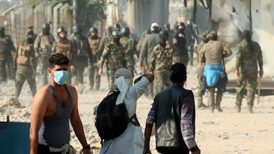 Protesters prepare to throw stones during clashes between Iraqi security forces and anti-government protesters, in Baghdad. AP Photo