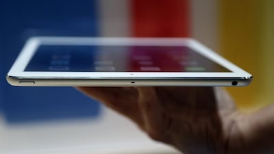 An Apple employee holds up the new iPad Air, a thinner, lighter tablet that weighs just 1 pound, compared with 1.4 pounds for the previous version. Marcio Jose Sanchez / AP Photo