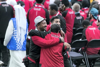 Members of the UAE team hug at the closing ceremony. Reem Mohammed / The National