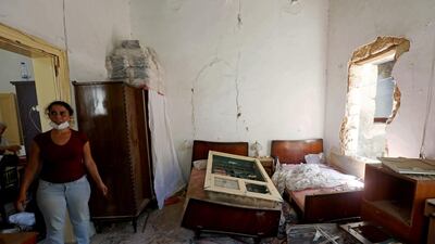 A woman stands inside her damaged home. Reuters