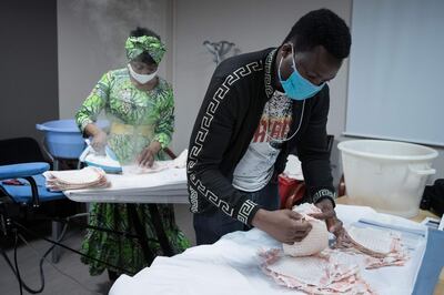 Undocumented immigrants iron homemade protective face masks for The Salvation Army in Paris. AFP
