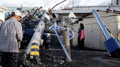 People look at an electric pole knocked down by Typhoon Maysak in the port of Ulsan. AFP