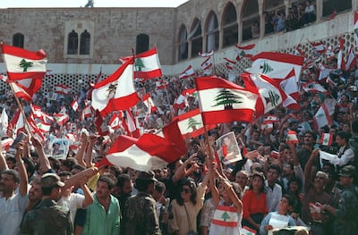 Christian Lebanese people wave national flags and portraits of General Aoun while they stage a protest on November 4, 1989 in front of Baabda Palace against the Taif Agreement. AFP