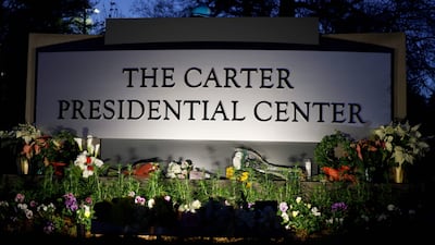 Signs and flowers sit neat the entrance of the Jimmy Carter Presidential Library. Getty Images / AFP