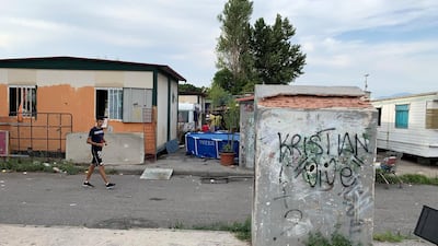 'A resident of the Salone Camp for Italy's Roma ethnic minority passes a static caravan; the camp, which is home to 400 inhabitants, lies 15km from the centre of Rome. Callum Paton / The National