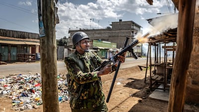A Kenyan police officer fires a tear gas launcher. AFP
