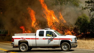 Flames from the Carr Fire lick above a Cal Fire truck in Whiskeytown, California. The flames moved so fast that firefighters working in oven-like temperatures and bone-dry conditions had to drop efforts to battle the blaze at one point to help people escape. AP Photo / Noah Berger