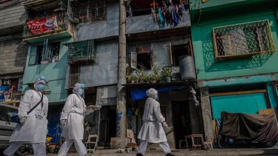 Health care workers (L-R) Vanessa Morales, Richell Arsenio and Fe Bacunawa prepare to enter an alley in Manila, Philippines. They are part of a group of four volunteer health workers who were nicknamed 'Astronauts' by residents of Village 775, Zone 84 in Manila as they resemble such when donning their protective equipment. The healthcare volunteers conduct home visits twice a day to people infected or suspected to be infected with the novel SARS-CoV-2 coronavirus that causes the COVID-19 disease in one of the densely populated villages in Manila. EPA