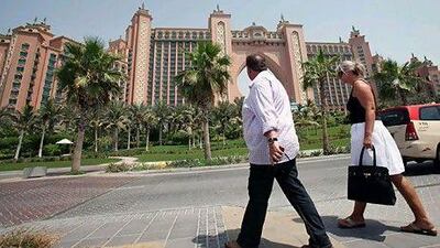 Foreign tourists walk in front of Atlantis in Dubai. Latest figures show the emirate has seen 300,000 more hotel visitors in the first nine months of 2010 than in the same period last year.