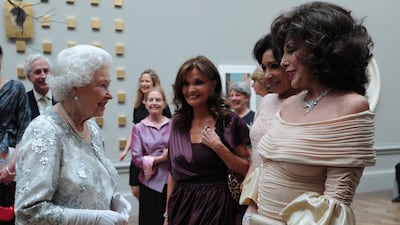 Queen Elizabeth speaks to actresses Joan Collins and Kate O'Mara and singer Shirley Bassey. Getty