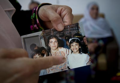 Fadwa Tlaib, an aunt of Rashida Tlaib, points to a young Rashida in a 1987 picture with her mother Fatima and brother Nader at the family house in the West Bank. AP