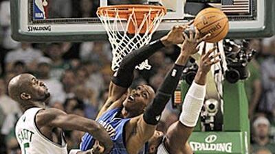 Orlando Magic center Dwight Howard, centre, battles Boston Celtics's Kevin Garnett, left, and Glen Davis for a rebound in the fourth quarter.