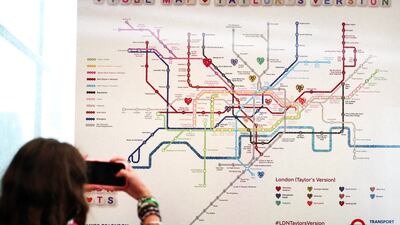 A fan takes a picture of a Swift-themed Tube map in London. EPA