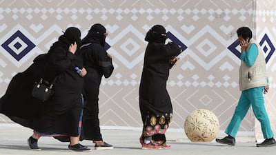 Saudi women wearing the required abaya are seen walking during the King Abdulaziz Camel Festival in Rumah, some 160 kilometres east of Riyadh, on January 19, 2018. Fayez Nureldine / AFP