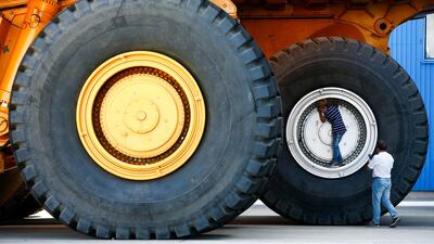 People take a selfie at the wheels of dump trucks at the Belarusian Autoworks manufacturer in Zhodino. Reuters