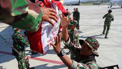 Soldiers unload relief supplies from a military aircraft in Palu. Reuters