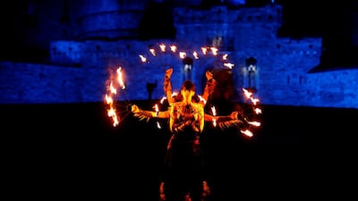 Members of PyroCeltica pose in front of Edinburgh Castle in advance of Edinburgh's Hogmanay torchlit procession. Reuters