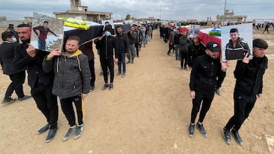 Mourners carry coffins of victims from Kocho in February 2021, after their remains were exhumed from a mass grave. Reuters