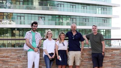 From left, Nasser Al Shamsi, Jennifer Al Hashimi, Brigitte Steyn, Sean Steyn and Richard Allen - residents of Al Bandar fighting to prevent the removal of two stray cats from the site at Al Raha Beach. Khushnum Bhandari / The National
