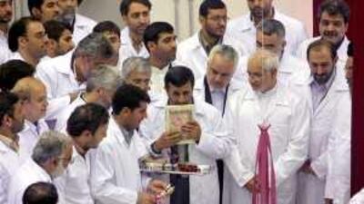 Mahmoud Ahmadinejad kisses the Quran during the opening of the nuclear fuel plant near Isfahan.