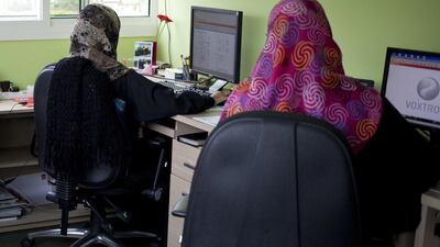 Employees at the Dubai Foundation for Women and Children take calls reporting mistreatment at the hotline centre. Razan Alzayani / The National