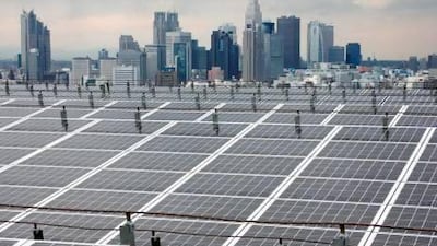Tokyo's Shinjuku district rises behind an array of solar panels displayed at Itochu Corporation's headquarters. Kimimasa Mayama / Bloomberg News