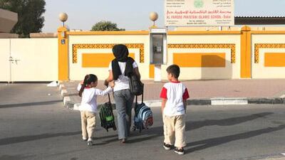 Yasmeen Hussein Ali waits with her two children Lielan, 4 and Yousef, 5 at the gates of Al Farooq Pakistani Islamic School. Mrs Ali had not known that the school has been closed.
