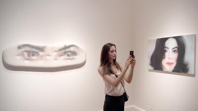A woman takes photographs during a press preview of the exhibition "Michael Jackson: On the Wall" at the National Portrait Gallery in London, Britain, on June 27, 2018. Neil Hall / EPA