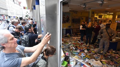 People take pictures of a supermarket that was vandalised during protests against the G20 summit in Hamburg, Germany, on July 8, 2017. Lukas Barth / EPA