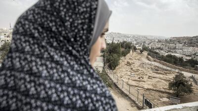 A Palestinian woman on the balcony of her home that overlooks the site.