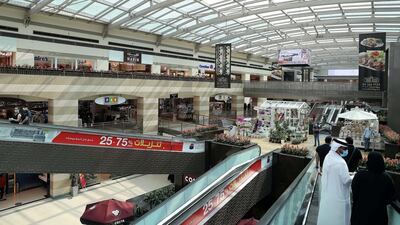 Shoppers on an escalator at Dubai Festival City mall in Dubai wearing masks during the Covid-19 outbreak. Companies need to improve both their online and offline offerings to entice customers to spend during the pandemic, says Manar Al Hinai. Pawan Singh / The National