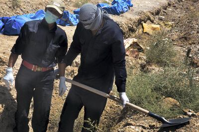 Members of the Civil Defence Unit use shovels to dig out bodies. Arianna Pagani for The National