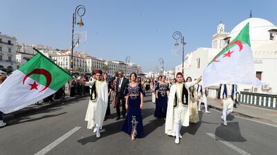 Algerian women wave the country's flag during a parade in Algiers. EPA
