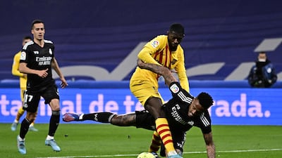 Real Madrid defender Eder Militao attempts to tackle Barcelona forward Ousmane Dembele. AFP
