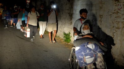 Refugees and migrants leave as a fire burns at the Moria refugee camp on the northeastern Aegean island of Lesbos, Greece. AP Photo