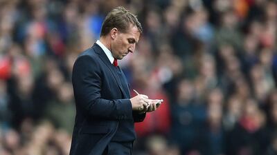 Liverpool manager Brendan Rodgers takes notes during his side's Premier League loss to Arsenal on Saturday. Ben Stansall / AFP / April 4, 2015