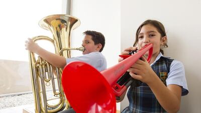 Hugo John, 11, and Alexandra Mitsis, 9, members of the Cranleigh School wind band, toot their horns. The Saadiyat Island school promotes extra-curricular activities such as sports, music and the arts to mould more confident and well-rounded pupils. Christopher Pike / The National