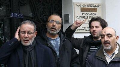 Men pray outside Al Rida mosque in the Anderlecht neighborhood of Brussels yesterday. The mosque's imam died of smoke inhalation following an arson attack on Monday.