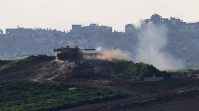An Israeli tank fires into the Gaza Strip as the war continues. Reuters
