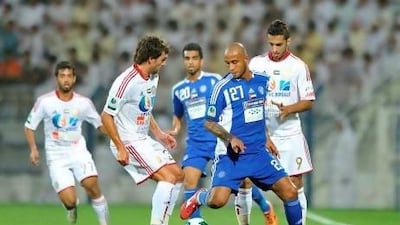 Leonardo Lima of Nasr (No 27) looks to wrest the ball from Al Jazira defenders. Ashraf Umrah / Al Ittihad