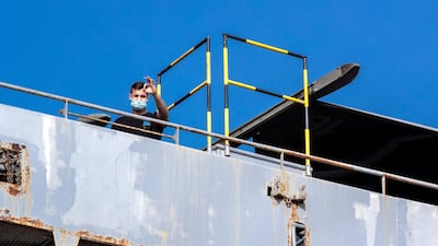 A crew member gives an ok sign. Victor Besa/The National