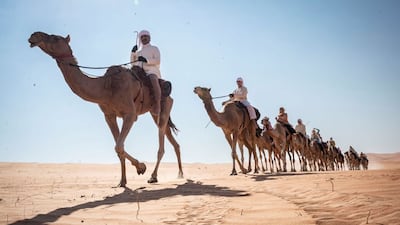 The riders make their way across the desert.