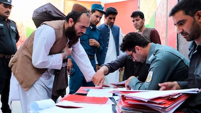Taliban prisoners have their documents checked before being released from Pul-e-Charkhi jail in Kabul on August 13, 2020. Afghanistan's National Security Council via AP