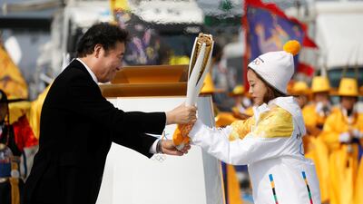 South Korean prime minister Lee Nak-yeon hands the Olympic torch to figure skating prospect and the first torchbearer of the country You Young on the Incheon bridge in Incheon, South Korea. Kim Hong-ji / Reuters
