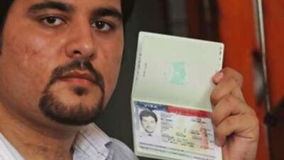 Zuhair Abu Shaban displays his Palestinian passport, stamped with a visa from the United States, which was later revoked, in Gaza.