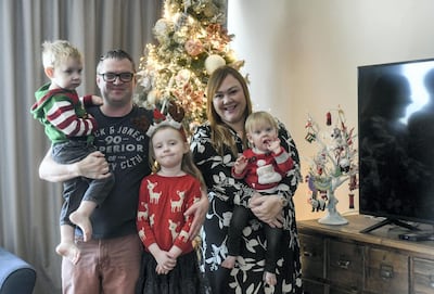 The Bradley family pose in front of their Christmas tree, which features baubles collected during their travels. Khushnum Bhandari for The National