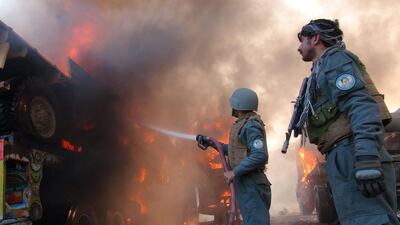 Afghan firefighters extinguish burning Nato military vehicles after a clash between Taliban and Afghan security forces in the Torkham area, near the Pakistan and Afghan border in Jalalabad. Omar Gul / AFP Photo