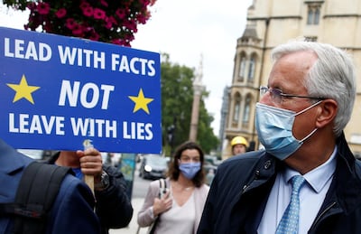 Anti-Brexit demonstrators hold placards as the EU's Chief Negotiator Michel Barnier walks to a meeting in Westminster, London, UK, September 9, 2020. Reuters