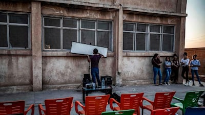 A member of Hinde's Komina Film initiative prepares a projector screen for a film screening.