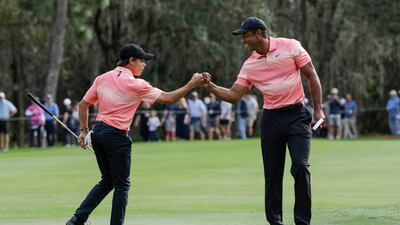 Tiger Woods, right and his son Charlie Woods bump fists on the ninth green during the first round of the PNC Championship golf tournament Saturday, Dec. 17, 2022, in Orlando, Fla. (AP Photo / Kevin Kolczynski)